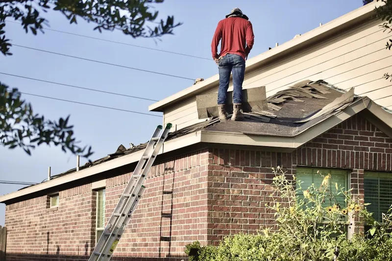 Professional roofer working on a residential roof in Winmore